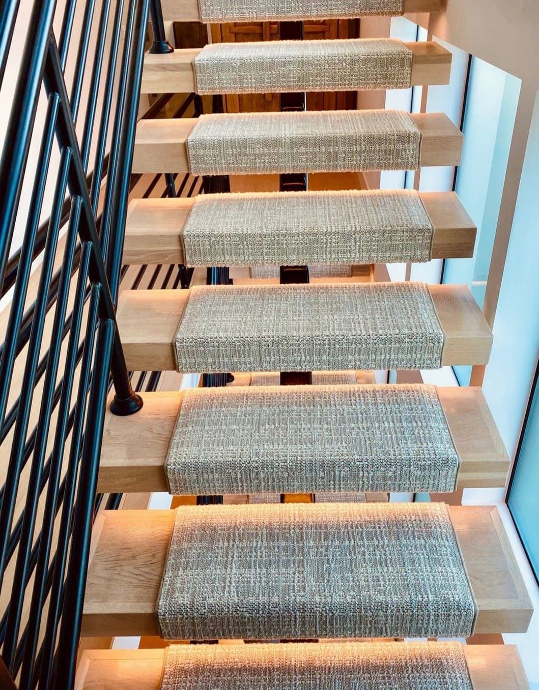 Floating wood staircase with woven treads and warm accent lighting
